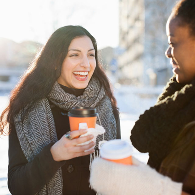 jenter som drikker kaffe ute om vinteren