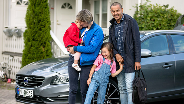 Familie står foran bil