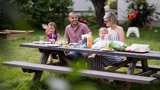 Familie spiser lunsj i parken